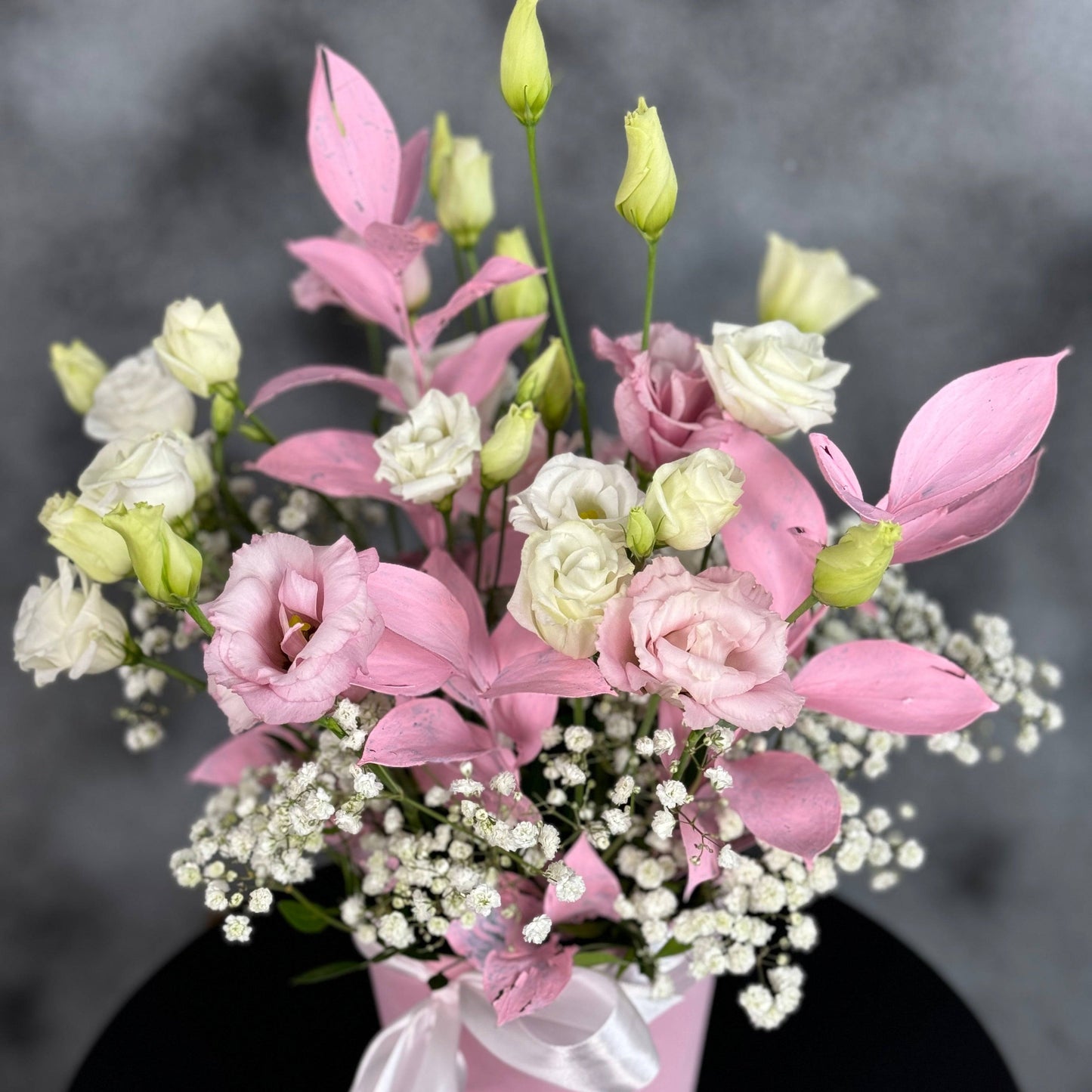 Aranjament cu eustoma albă și roz, gypsophila și ruscus