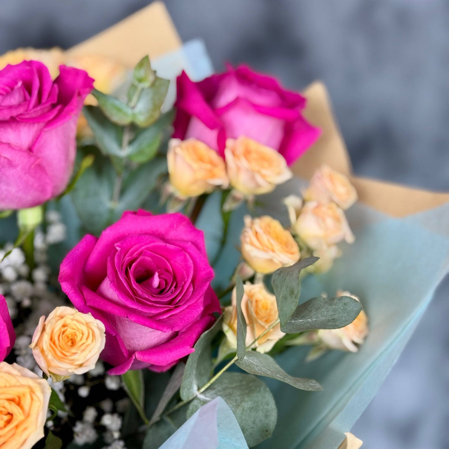 Aranjament floral elegant cu trandafiri roz și nuanțe calde de peach, ideal pentru aniversări sau zile onomastice.