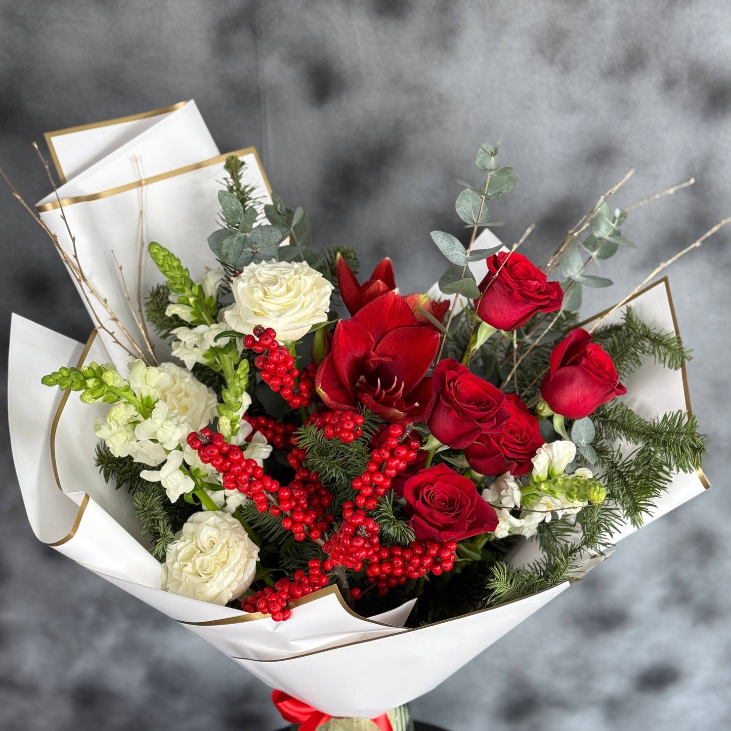 Aranjament floral festiv cu nuanțe de roșu și alb, ideal pentru sărbători