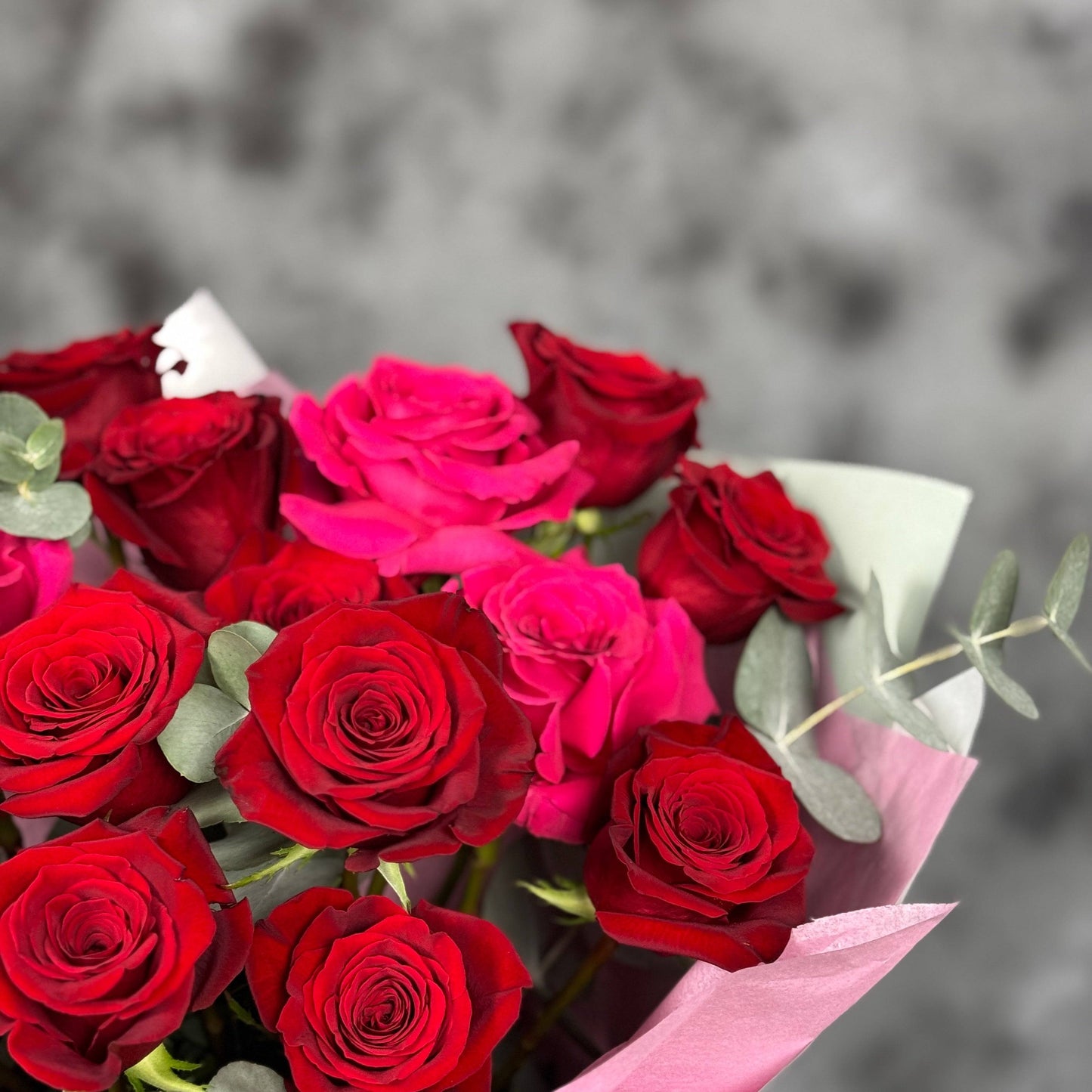 Aranjament floral sofisticat cu trandafiri și eucalipt, perfect pentru aniversări sau momente speciale