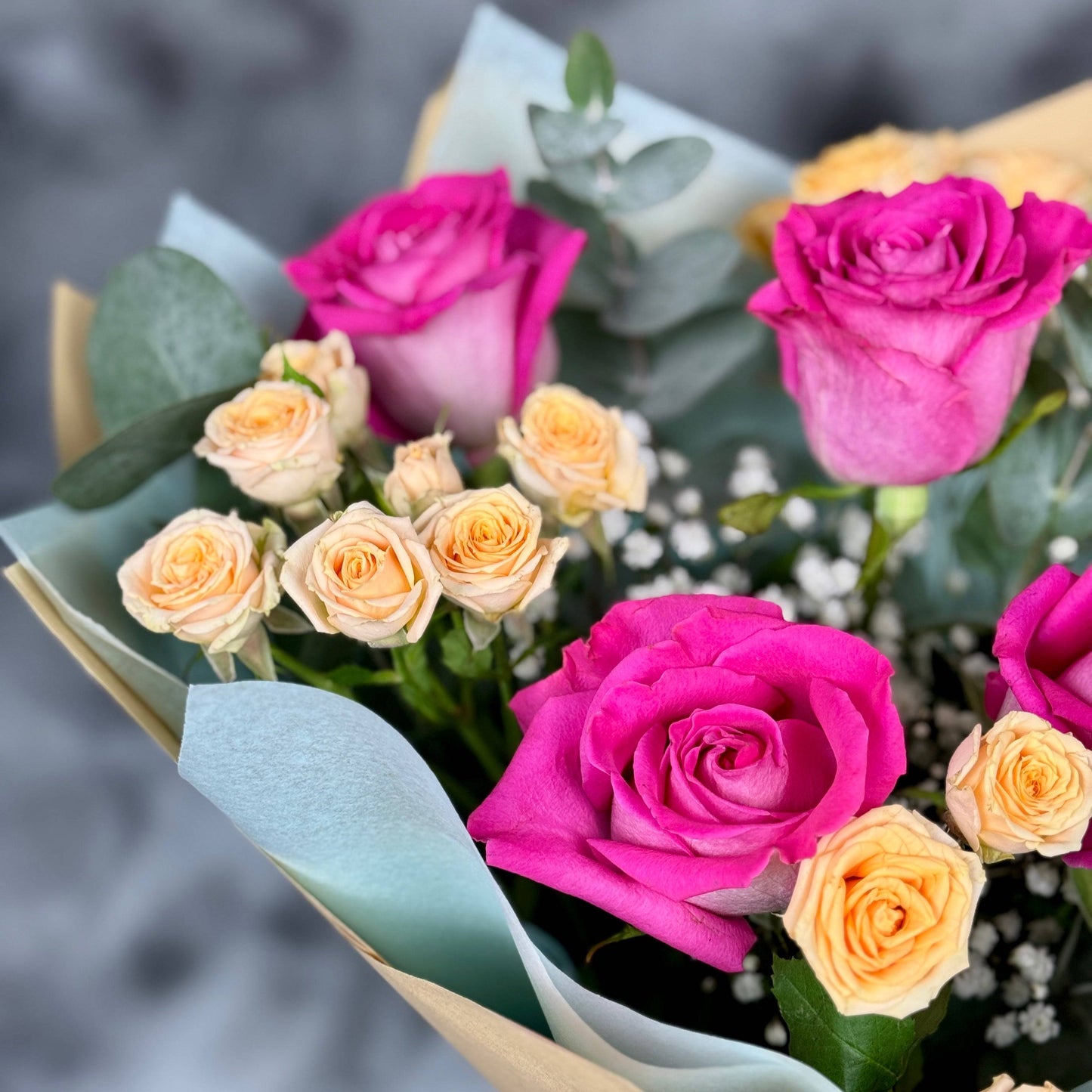 Aranjament floral pastelat cu trandafiri roz și minirose peach, simbol al eleganței și rafinamentului.