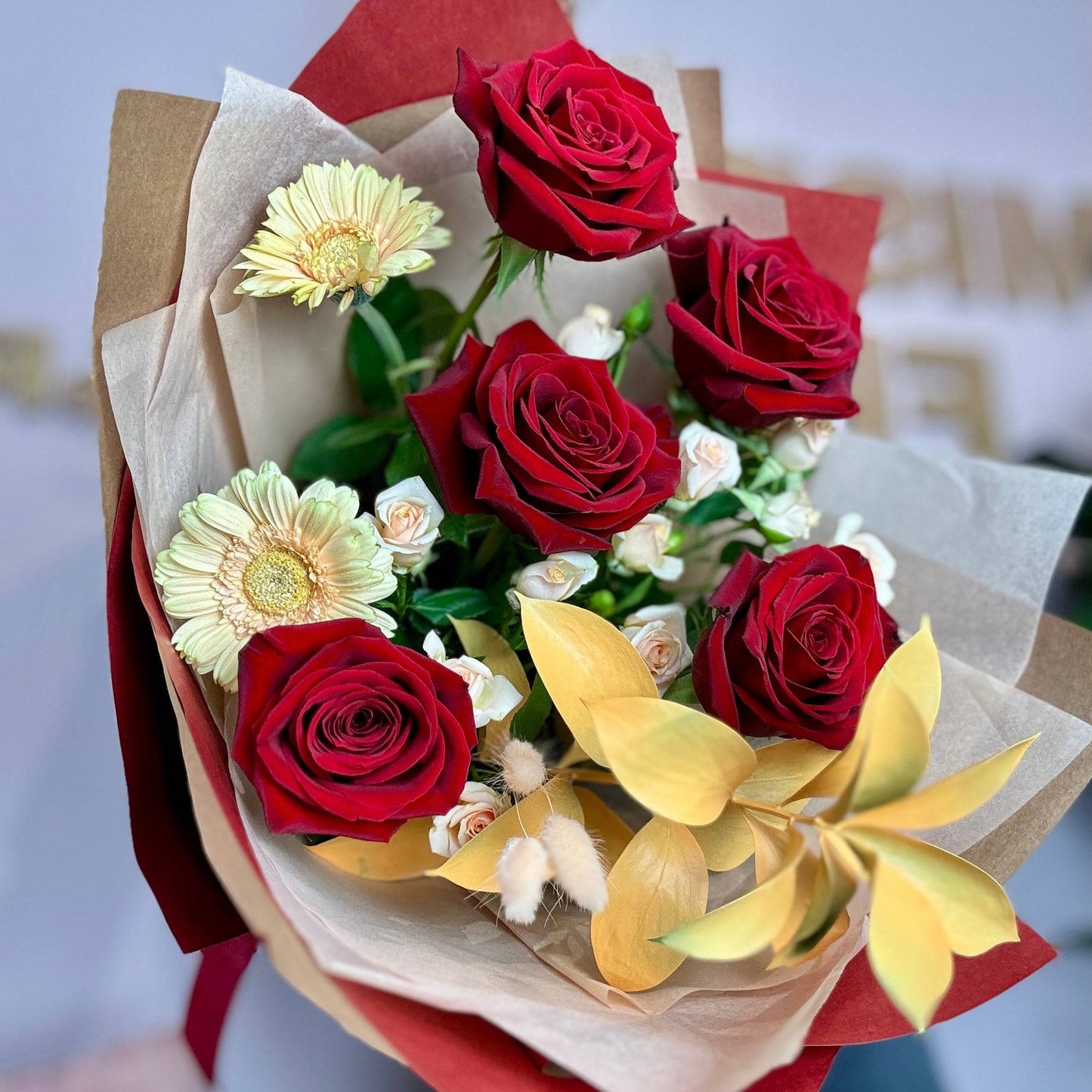 Buchet elegant cu trandafiri roșii, minirose peach și germini, ideal pentru cadouri romantice. Livrare rapidă în Cluj și Florești.