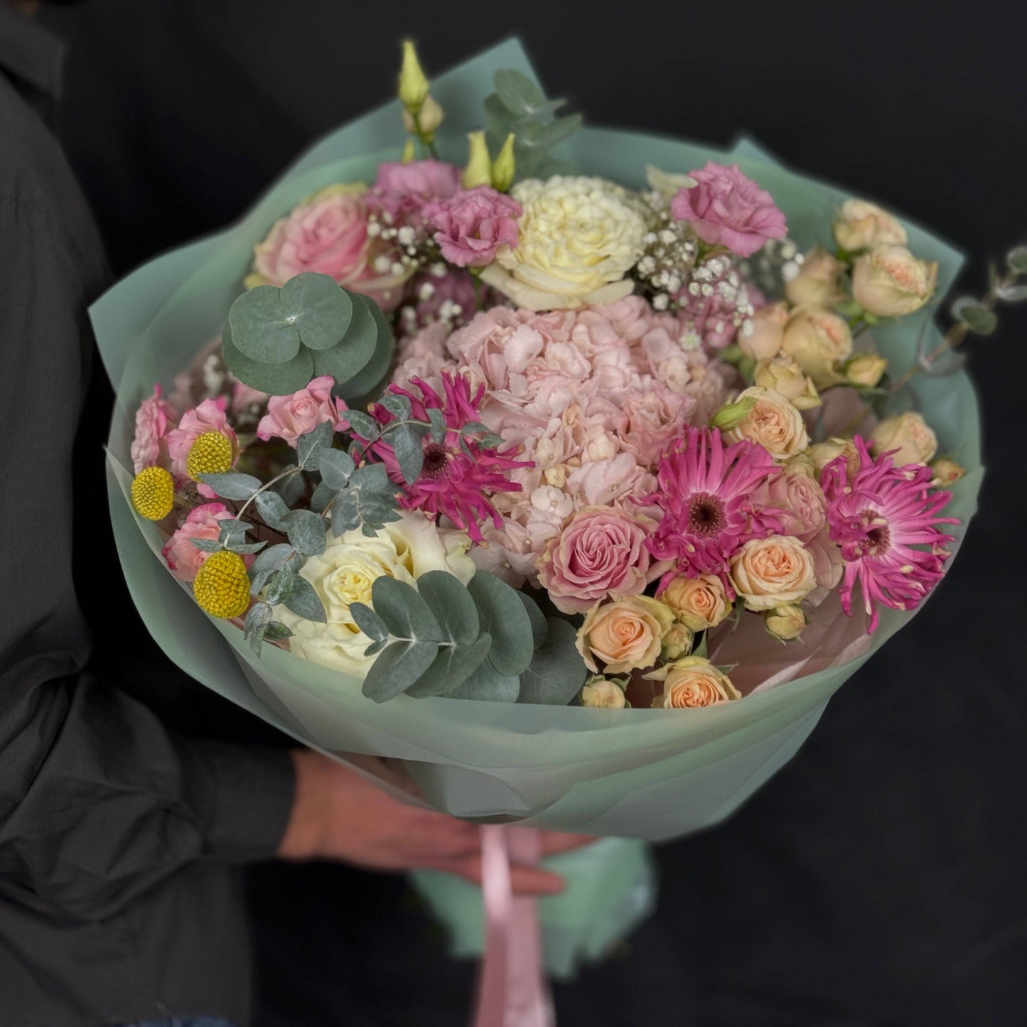 Buchet rotund cu flori pastelate – trandafiri, hortensii, gerbera și eucalipt, perfect pentru cadouri și evenimente speciale.