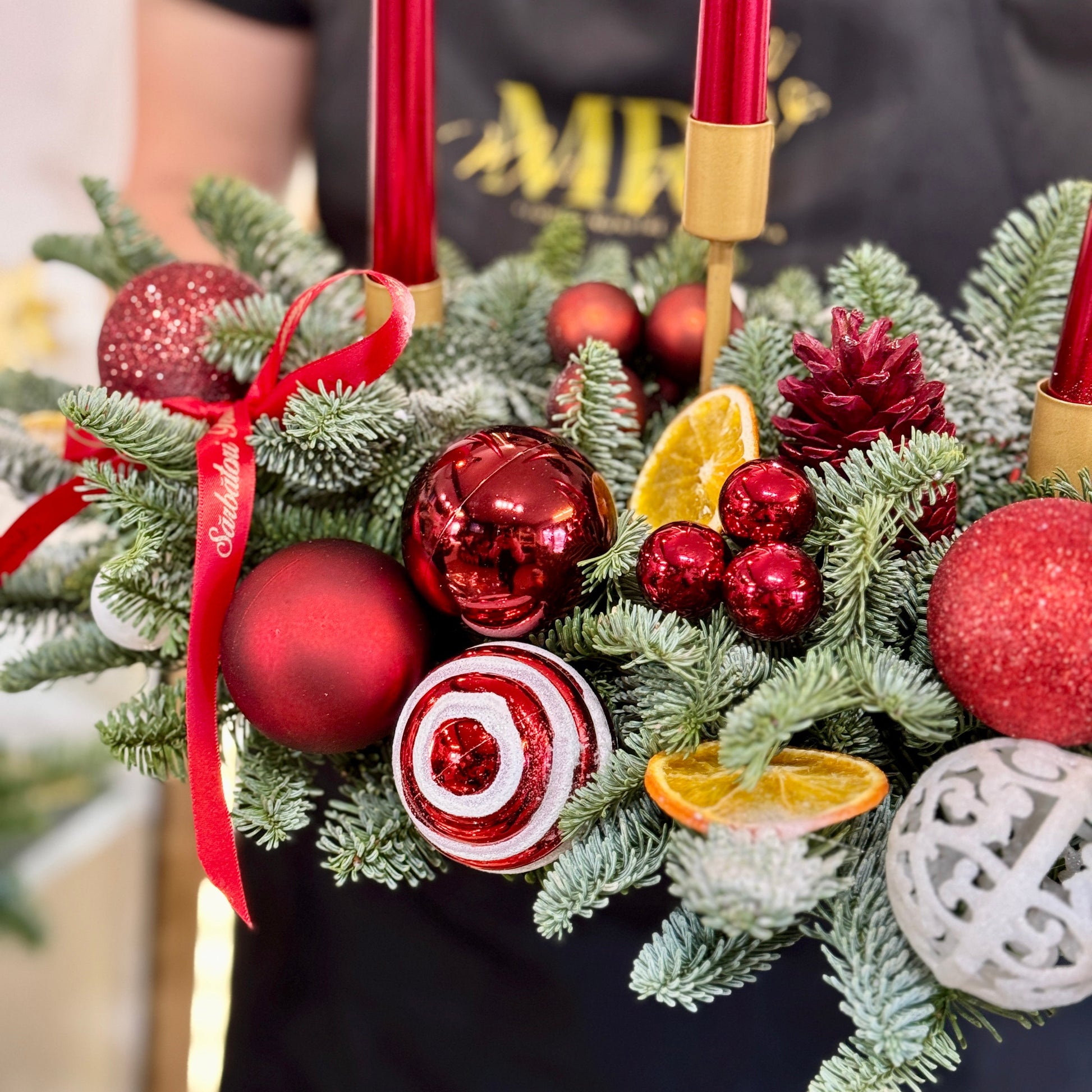 Aranjament festiv de Crăciun cu globuri roșii și conuri