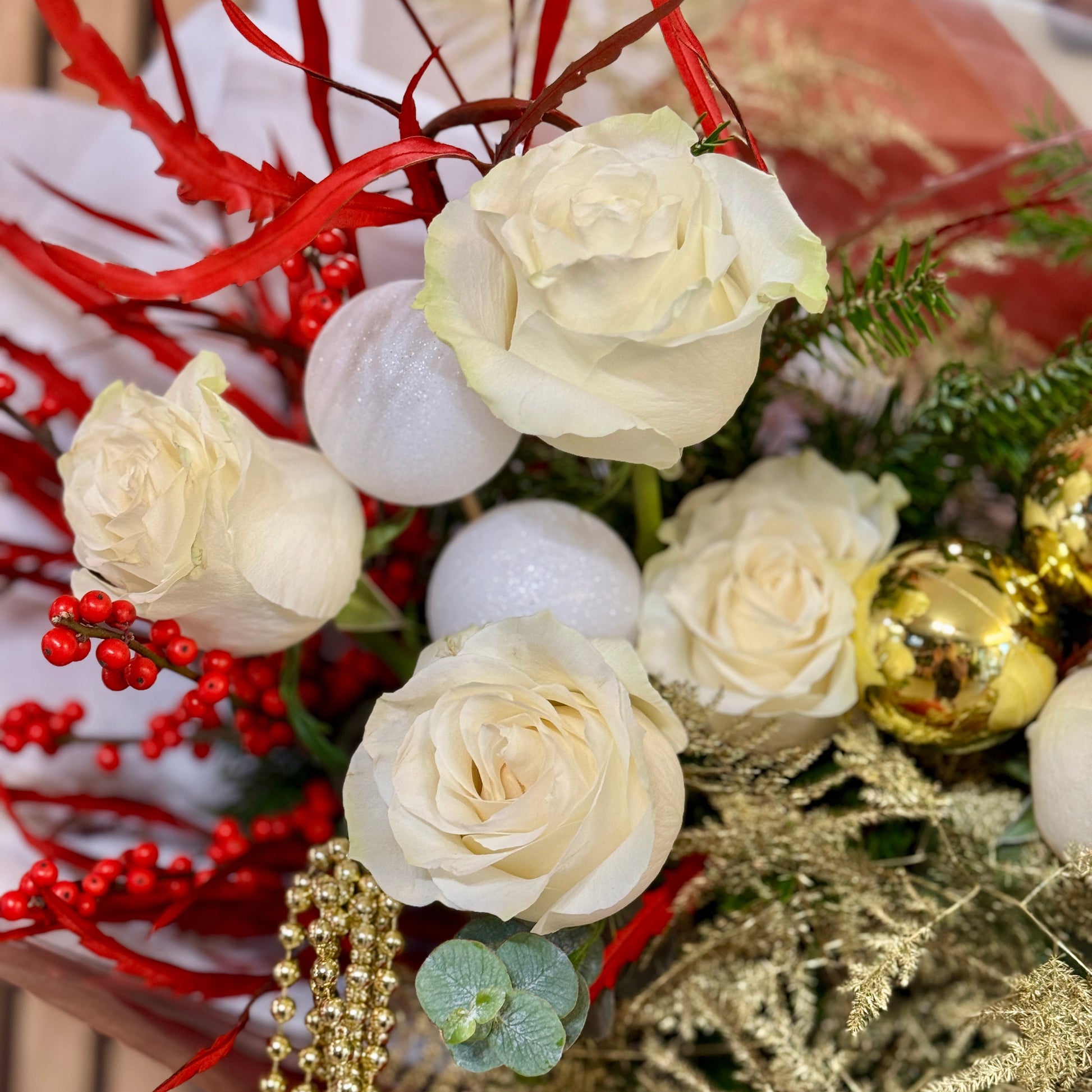 Aranjament floral cu trandafiri albi, bobițe roșii și brad natural