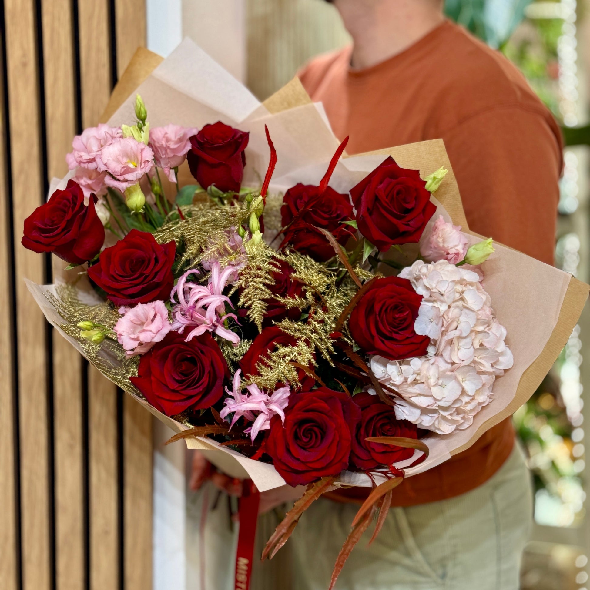 Aranjament floral romantic cu trandafiri roșii și flori roz pastel