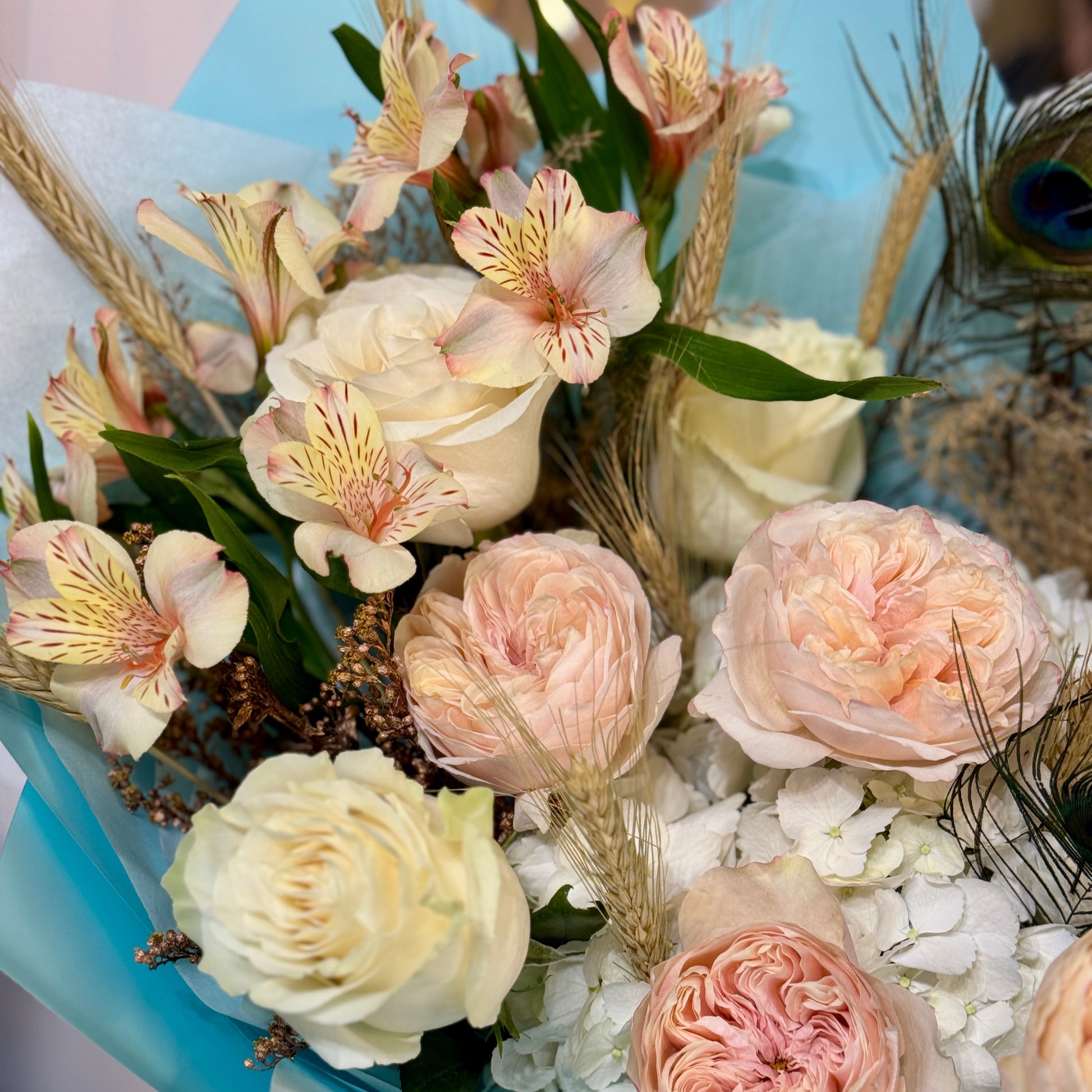 Buchet de flori La Vie en Bleu cu trandafiri, alstroemeria, hortensie și accente decorative cu pene de păun